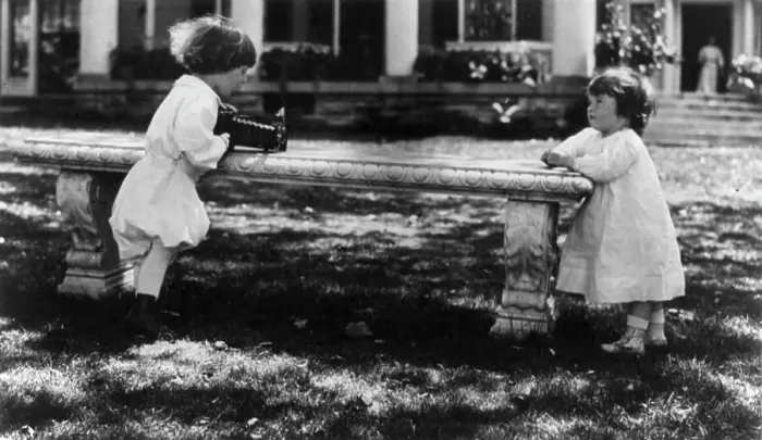 Framed Print : One child aiming camera, on bench, at another child, Washington, D.C. between c1890 and c1910. Creator: Frances Benjamin Johnston Framed Print : One child aiming camera, on bench, at another child, Washington, D.C. between c1890 and c1910. Creator: Frances Benjamin Johnston