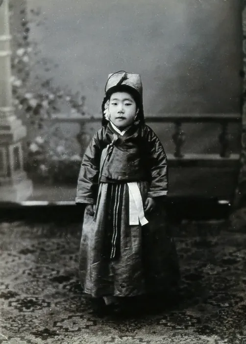 Framed Print : A child posing in front of a painted backdrop in a photographic studio, c1900. Creator: Unknown Framed Print : A child posing in front of a painted backdrop in a photographic studio, c1900. Creator: Unknown
