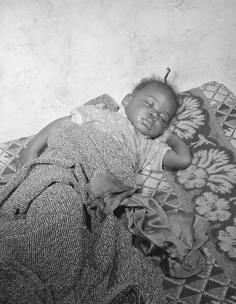 Child seriously ill from an infection caused by a rat bite in her home... Washington, D.C. 1942. Creator: Gordon Parks