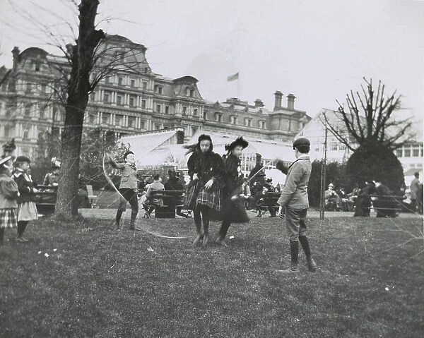 Children jumping rope on the White House lawn during annual Easter egg roll with State, War...1898. Creator: Frances Benjamin Johnston