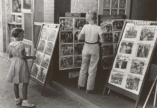 Children looking at posters in front of movie, Saturday, Steele, Missouri, 1938-08. Creator: Russell Lee