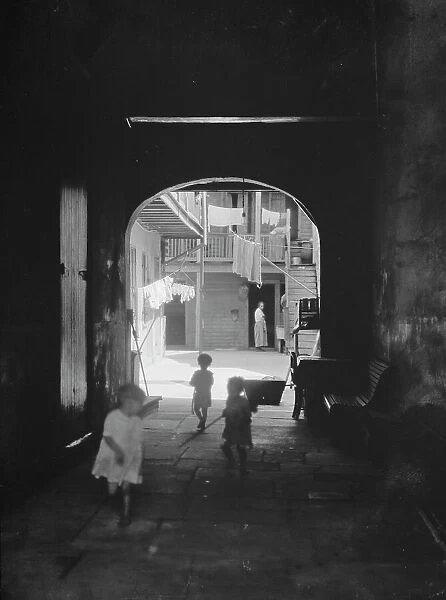 Children playing in an arched passageway, New Orleans, between 1920 and 1926. Creator: Arnold Genthe