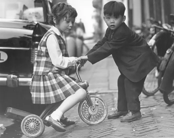 Framed Print : Children playing with a tricycle, c1960s Framed Print : Children playing with a tricycle, c1960s