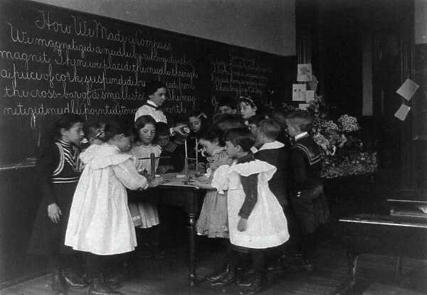Children in school in Washington, D.C. - learning how a compass is made, (1899?). Creator: Frances Benjamin Johnston