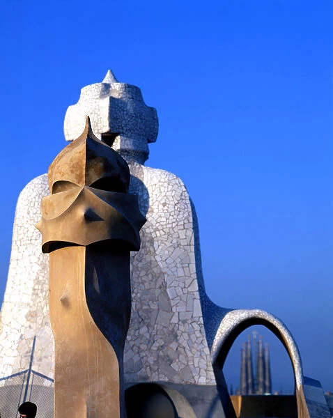 Detail of the chimneys of La Pedrera or Mila House with the Sagrada Familia at background