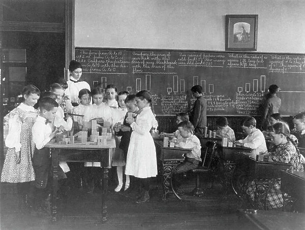 Classroom scene in Washington, D.C. elementary school - children working with blocks... (1899?). Creator: Frances Benjamin Johnston