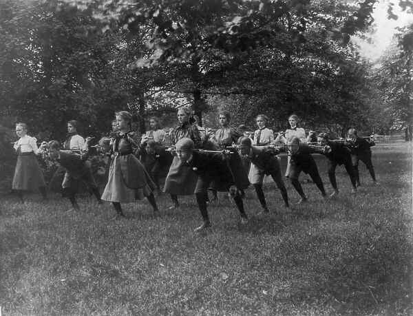 Classroom scenes in Washington, D.C. public schools - outdoor exercise with rods... (1899?). Creator: Frances Benjamin Johnston