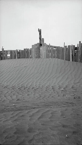 A corral practically buried by drifted dust, Mills, New Mexico. 1935. Creator: Dorothea Lange