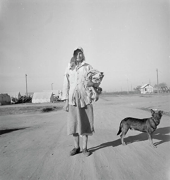 Cotton picker on her way to the cotton field, Kern migrant camp, California, 1936. Creator: Dorothea Lange