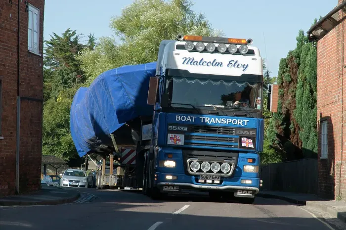 Framed Print : DAF 95 XF wide load truck carrying a life boat through a small village Framed Print : DAF 95 XF wide load truck carrying a life boat through a small village