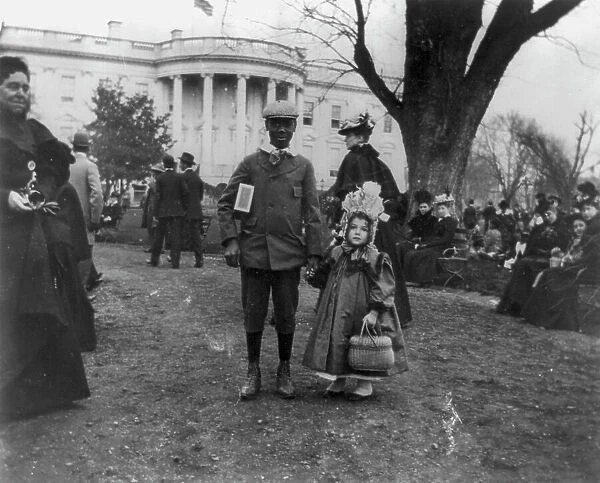 D.C. Wash. - White House - Negro boy holding hand of small white girl during Easter egg roll, 1898. Creator: Frances Benjamin Johnston