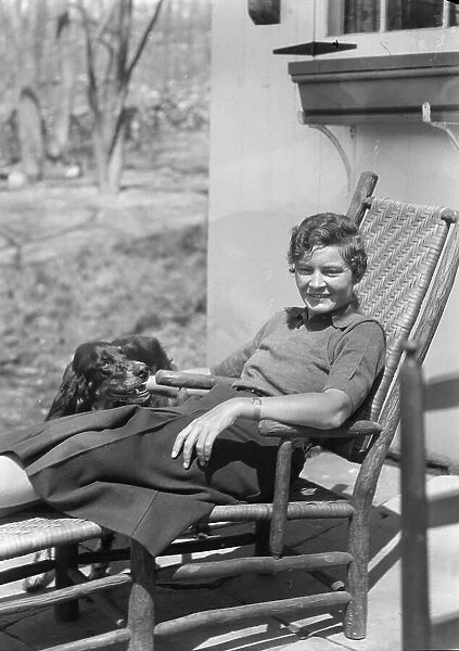DeLamar, Alice, Miss, with dog, seated outdoors, between 1927 and 1942. Creator: Arnold Genthe