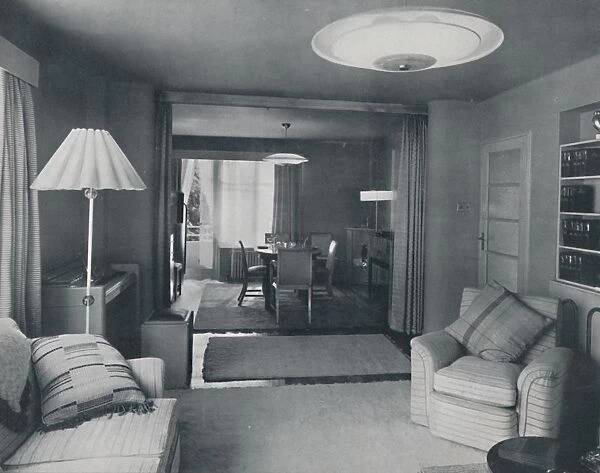 Dining and living room, divided only by heavy curtains in an attractive modern weave, 1942