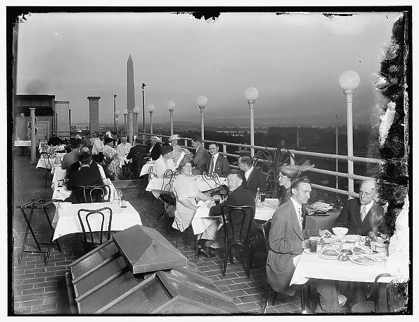 Dining on rooftop; Washington monument in background, between 1910 and 1920. Creator: Harris & Ewing. Dining on rooftop; Washington monument in background, between 1910 and 1920. Creator: Harris & Ewing