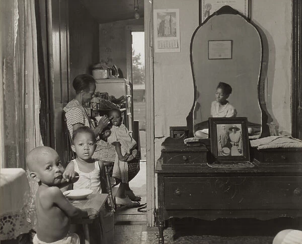 Dinner time at the home of Mrs. Ella Watson, a government charwoman, Washington, D. C. 1942. Creator: Gordon Parks
