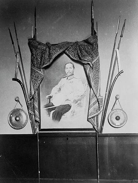 Display with portrait of a man, possibly Chulalongkorn, King of Siam, in Siam exhibit... 1904. Creator: Frances Benjamin Johnston