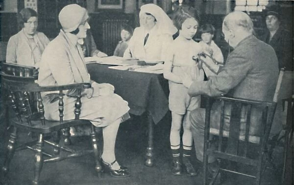 The Doctor listening to a childs heart beat, c1935