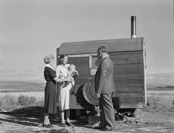 The doctor reassures the mother... the sick baby, Merrill, Klamath County, Oregon, 1939. Creator: Dorothea Lange
