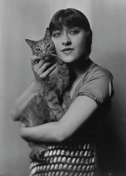 Dolly sister, with Buzzer the cat, portrait photograph, 1916. Creator: Arnold Genthe
