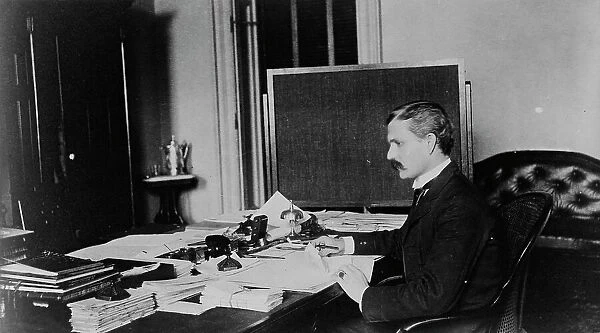 Dr. Miller, Treasury Department employee, half-length portrait, seated at... between 1884 and 1930. Creator: Frances Benjamin Johnston