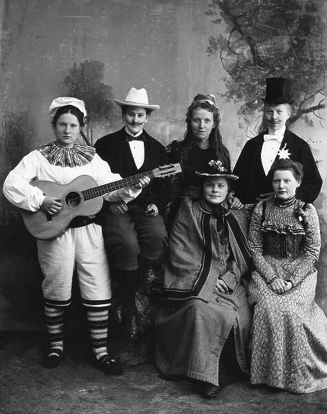 Six dressed-up youngsters, one of the young people plays the guitar, 1910-1920. Creator: Hans Per Persson