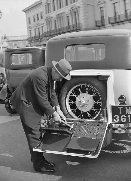 A driver opening the fitted toolkit of his Ford Model A at the Southport Rally, 1928