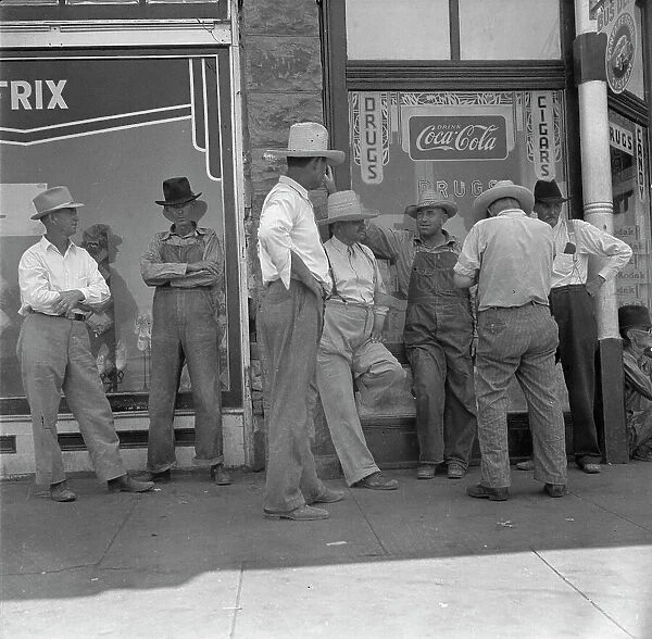Drought farmers line the shady side of the main street of the town, Sallisaw, Oklahoma, 1936. Creator: Dorothea Lange