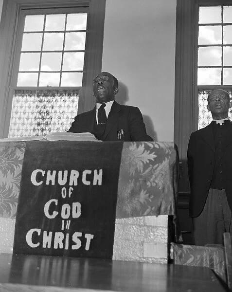 Elder Kelsey, pastor of the Church of God in Christ, opening a service... Washington, D.C. 1942. Creator: Gordon Parks