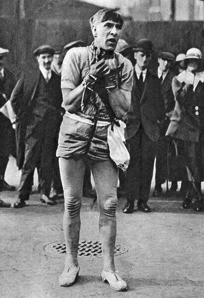 Escapologist entertaining theatre-goers in the pit queue, London, 1926-1927