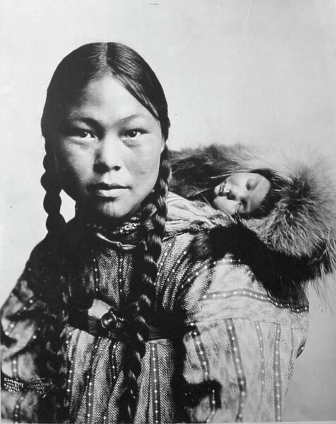 Eskimo mother with child on back, c1906. Creator: Lomen Brothers