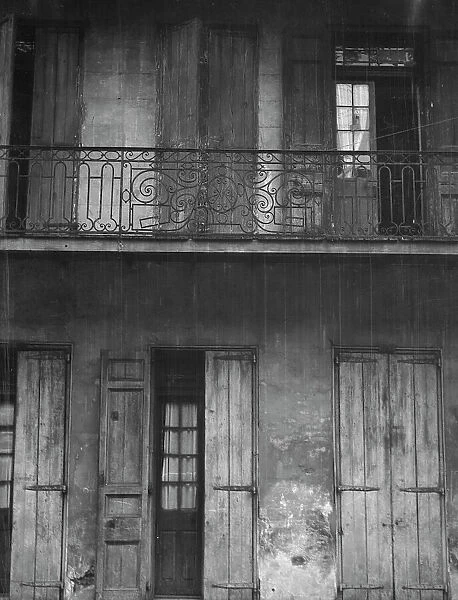 Facade of a building with shuttered doors and balcony, New Orleans or Charleston... c1920-1926. Creator: Arnold Genthe