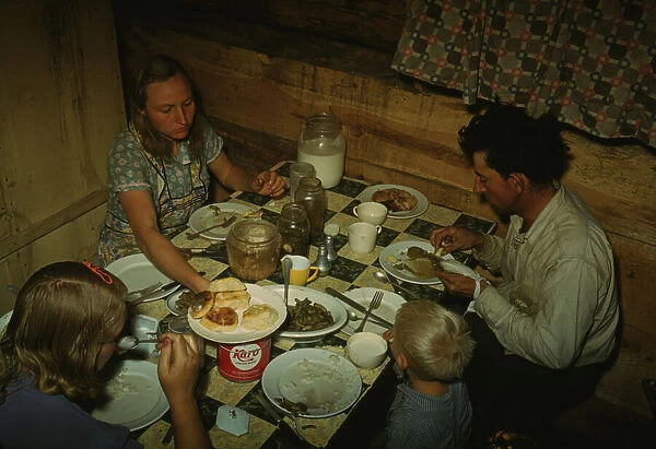 The Faro Caudill family eating dinner in their dugout, Pie Town, New Mexico, 1940. Creator: Russell Lee