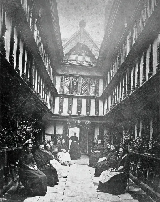 Framed Print : Ford's Hospital, Coventry: residents seated in the courtyard looking toward the street, c1880s Framed Print : Ford's Hospital, Coventry: residents seated in the courtyard looking toward the street, c1880s