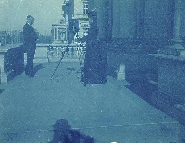 Frances Benjamin Johnston on a balcony of the State, War and Navy Building with a tripod... 1888. Creator: Frances Benjamin Johnston