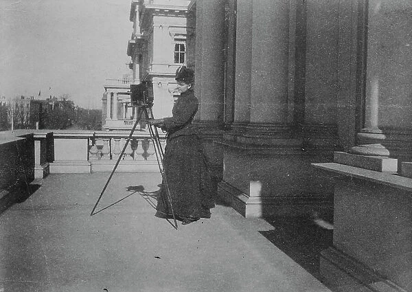 Frances Benjamin Johnston with camera on balcony of State, War and Navy Building... 1888. Creator: Frances Benjamin Johnston