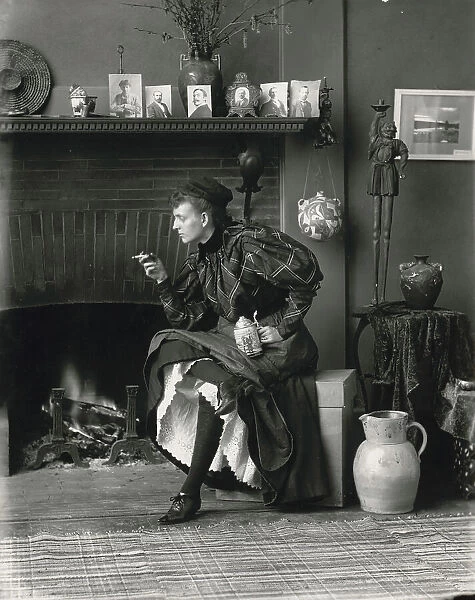 Frances Benjamin Johnston, full-length portrait, seated in front of fireplace, facing left... 1896. Creator: Frances Benjamin Johnston