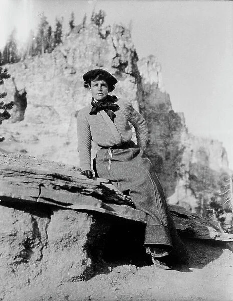 Frances Benjamin Johnston, full-length portrait, seated on rock in Yellowstone National Park, 1903. Creator: Frances Benjamin Johnston