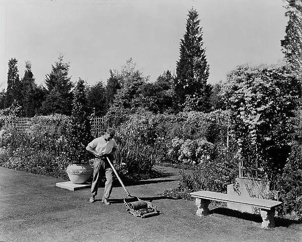 Gardener pushing lawn mower, posed to illustrate Rudyard Kipling's poem The Glory of the Garden, 1917 Creator: Frances Benjamin Johnston