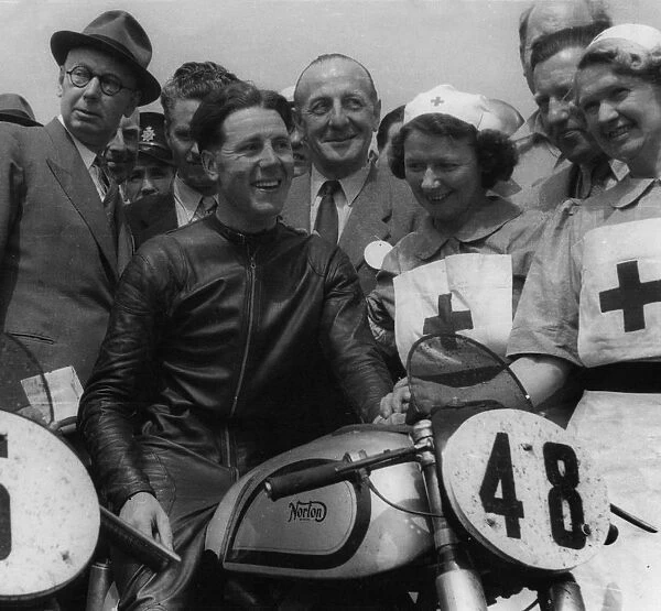 Geoff Duke on Norton, with nurses after race in 1951. Creator: Unknown