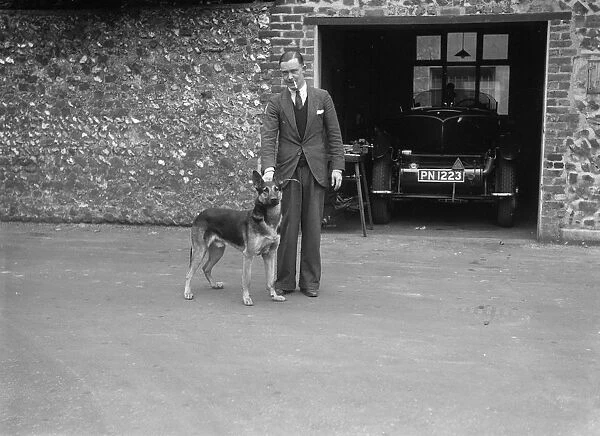 Geoffrey Baker standing in front of a Minerva 5954 cc car. Artist: Bill Brunell