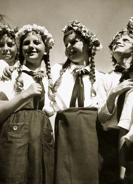 Four German girls smiling with garlands in their hair, c1936