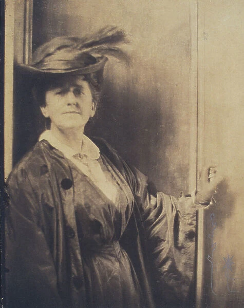 Gertrude Ka¨sebier, wearing feathered hat, standing, facing front, half-length portrait, c1900. Creator: Adolph de Meyer