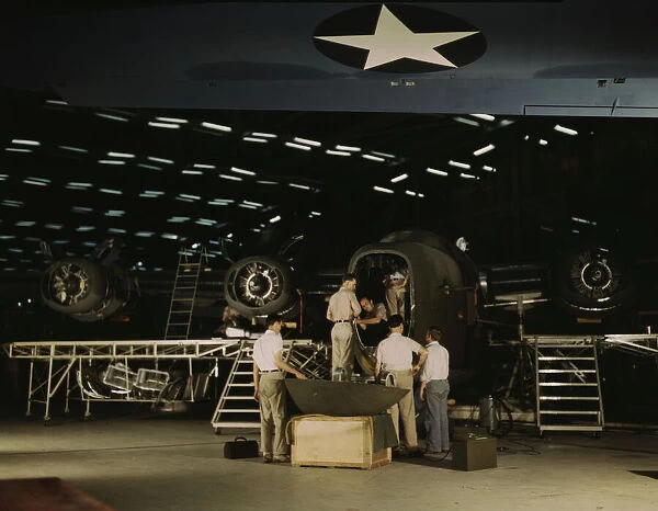 Getting a nose door ready to put on a C-87... Consolidated Aircraft Corp... Fort Worth, Texas, 1942. Creator: Howard Hollem