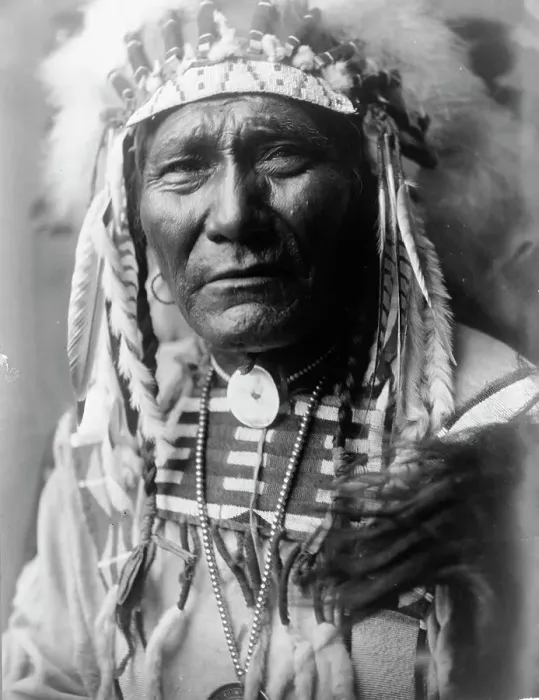 Framed Print : Ghost Bear, Crow Indian, Montana, head-and-shoulders portrait, facing front, feather... c1908. Creator: Edward Sheriff Curtis Framed Print : Ghost Bear, Crow Indian, Montana, head-and-shoulders portrait, facing front, feather... c1908. Creator: Edward Sheriff Curtis