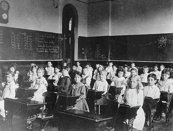 Girls and boys seated at desks in classroom, Washington, D.C. (1899?). Creator: Frances Benjamin Johnston