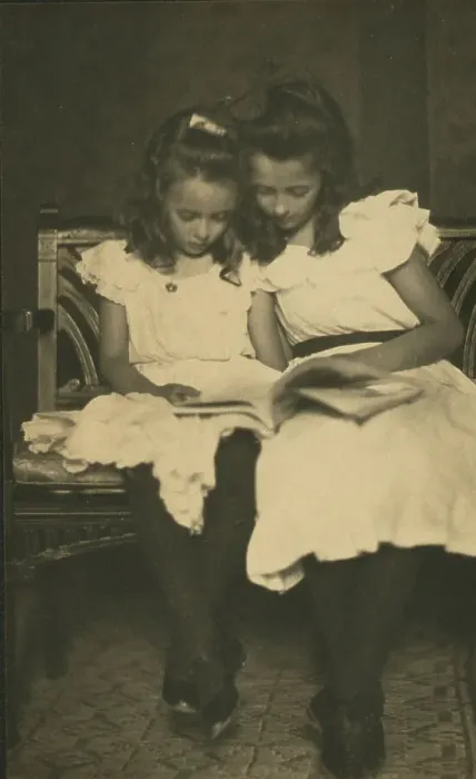 Framed Print : Two girls wearing white dresses and dark stockings reading a book, c1900. Creator: Virginia M Prall Framed Print : Two girls wearing white dresses and dark stockings reading a book, c1900. Creator: Virginia M Prall