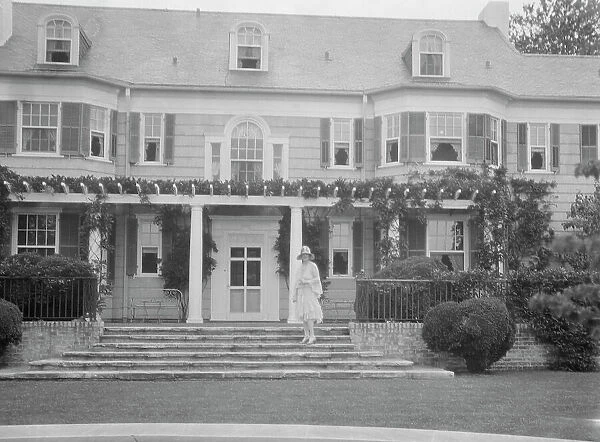 Gossler, Philip, Mrs. standing in front of residence, between 1927 and 1929. Creator: Arnold Genthe