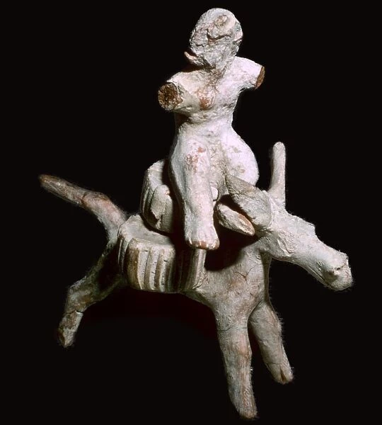 Greek terracotta figure of a man seated on three cheese on top of a mule, Corinthian
