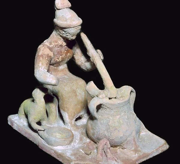 Greek terracotta statuette of a woman cooking