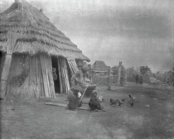 Group of Ainu outside a hut, 1908. Creator: Arnold Genthe